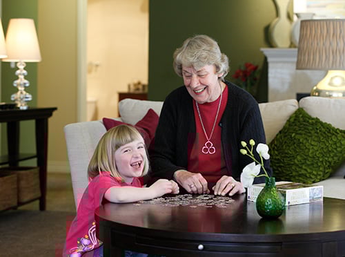 Grandmother working on a puzzle with her granddaughter